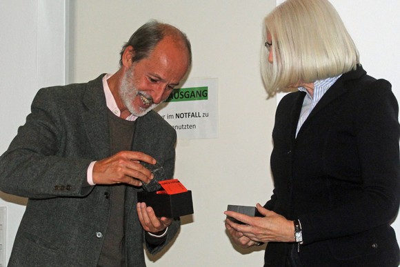 Dr. Carlos Collado Seidel erhält nach seinem spannenden Vortrag von Christiane Biechele aus dem Planungs-Team der Veranstaltungsreihe das übliche Geschenk für Schriftsteller und Referenten: einen Literaturpflaster-Stein. (Foto: Jens Gesper)