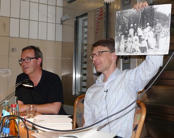 Markus Nummi (rechts) zeigt ein ins Buch 'Am Anfang ein Garten' eingearbeitetes Foto des einstigen finnischen Staatspräsidenten Carl Gustaf Mannerheim, aufgenommen zu Beginn des 20. Jahrhunderts in einer Missionsstation in Asien. (WP-Foto: Christiane Sandkuhl)
