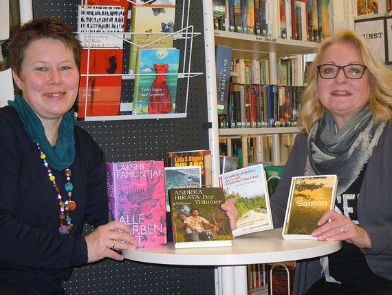Monika Schröder (links) von der Buchhandlung MankelMuth überreicht Büchereileiterin Gabriele Klotz die signierten Exemplare der Literaturpflaster Autoren 'Indonesien'. (Foto: Rikarde Riedesel)