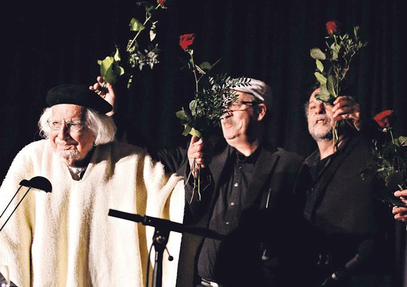 Das Publikum erhob sich für Ernesto Cardenal (l.), die Band 'Grupo Sal Duo' (Hintergrund) tat es den Besuchern gleich – und applaudierte dem Mann mit der schwarzen Baskenmütze und dem weißen Poncho für seinen Kampf für die Gerechtigkeit. (SZ-Foto: Timo Karl)