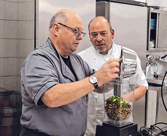 Kursteilnehmer Karl-Heinz Roth (l.) holte sich beim Pürieren der gewürzten Walnuss-Masse Tipps von Koch Hans-Christian Radenbach. (SZ-Foto: Alexander Kollek)