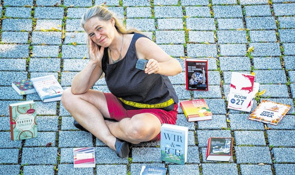 Auf dem kleinen Stein steht 'Literatur', und auf den großen Pflastersteinen sitzt zwischen den Büchern die Organisatorin Rikarde Riedesel. (WP-Foto: Matthias Graben)