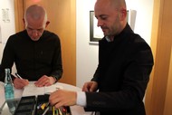 Ausstellung: 'Reading Images - Wenn aus Worten Bilder werden' von Tom Schoonooghe; Stefan Boonen signiert and Tom Schoonooghe illustriert ein Buch; Foto: Jens Gesper