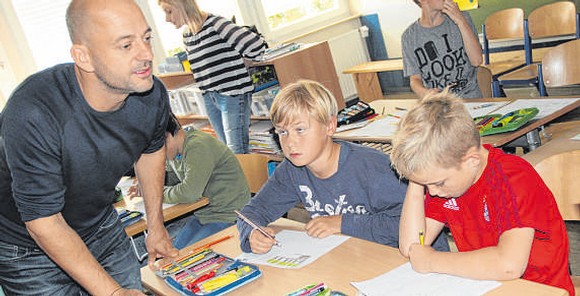 Tom Schoonooghe gibt den Grundschulkindern Tipps, wie sie mit ihrer ganz eigenen Fantasie Zeichnungen aufs Papier bringen. Und der Illustrator ist begeistert von den Ergebnissen. (WP-Foto: Ute Schlapbach)