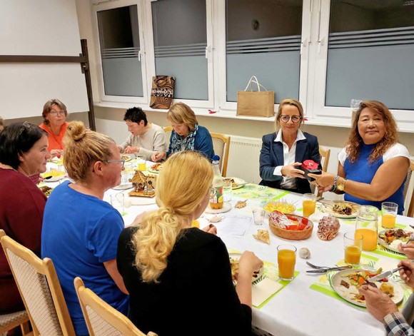 Beim gemeinsamen Essen übergibt Jenny Henk von der VHS Josephine Saßmannshausen feierlich den Literaturpflaster-Stein als Dankeschön für ihren Einsatz. (Foto: Nora Denker)
