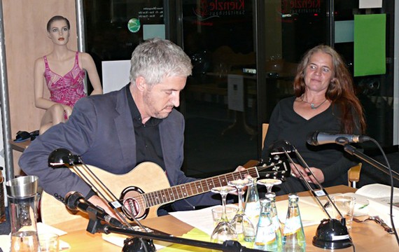 Spontan griff der neuseeländische Autor Anthony McCarten zur Gitarre und zeigte den erstaunten Zuhörern, dass er nicht nur auf dem Literatursektor Weltklasse ist. Schaufensterpuppe und Rikarde Riedesel hören andächtig zu. (WP-Foto: Christiane Sandkuhl)