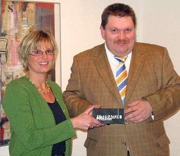 Bettina Born überreicht Ulf Lückel nach dessen Vortrag einen Literaturpflaster-Stein. (WR-Foto: Tim David Wolf)