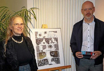 Da der Künstler Archie Oclos und der Verleger Jan Karsten nur per Computer zugeschaltet sind, ist Volksbank-Vorstand Kai Wunderlich der Einzige, der von Rikarde Riedesel bei der Ausstellungseröffnung einen der beliebten Literaturpflastersteine bekommt. (Foto: Stadt Bad Berleburg / Literaturpflaster)