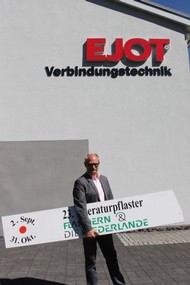 Pressekonferenz am 24.08.2016: Andreas Wolf (EJOT) hält Schild mit der Lautzeit des Berleburger Literaturpflasters in der Hand; Foto: Rikarde Riedesel