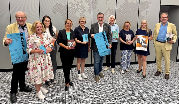 Das Team des Literaturpflasters freut sich gemeinsam mit zahlreichen Unterstützenden, darunter auch die Firma EJOT mit ihrem Geschäftsführer Christian Kocherscheidt, auf zahlreiche Veranstaltungen im Herbst – und darauf, die große Vielfalt der Philippinen nach Bad Berleburg zu holen. (Foto: Stadt Bad Berleburg)