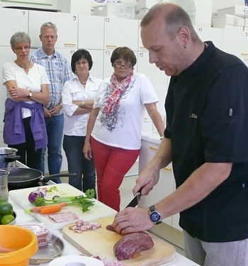 Der Profi Jörg Klein erntete viele neugierige Blicke, bevor die Aufforderung zum Selbermachen an die Teilnehmer des Kochkurses 'Brasilien' ging. (WP-Foto: Christiane Sandkuhl)