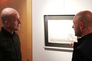 Ausstellung: 'Reading Images - Wenn aus Worten Bilder werden' von Tom Schoonooghe; Tom Schoonooghe (rechts) erläutert Stefan Boonen (Autor) eine Illustration in der Volksbank Wittgenstein; Foto: Jens Gesper