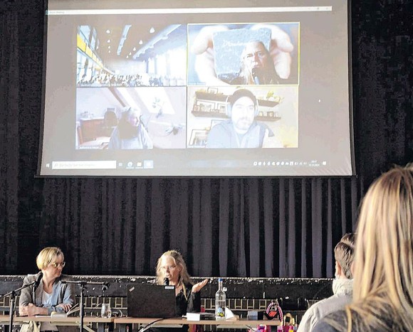 Der kanadische Bestsellerautor David A. Robertson (auf der Leinwand im Hintergrund unten rechts) gab bei der von Bettina Born (l.) und Rikarde Riedesel moderierten Veranstaltung in der Aula des JAG einen Einblick in seine Cole-Harper-Trilogie. (SZ-Foto: Lars Lenneper)