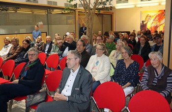 Gut 80 Besucherinnen und Besucher verfolgen die Ausstellungseröffnung. (Foto: Jens Gesper)